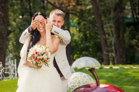 Beauty young couple of bride and groom in wedding suits in the parkの写真素材