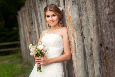 Bride in front of wooden rustic fence close-up pictureの写真素材