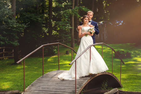 Wedding couple standing on old wooden bridge in forestの写真素材