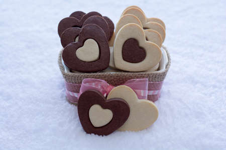 Pretty Rolled Vanilla and Chocolate Heart Sugar Cookies in a Ceramic bowl wraps with Burlap with the white rug backgroundの写真素材
