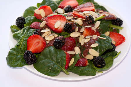 Strawberry Spinach Salad with Strawberry Vinaigrette Dressing decorated with Slice Almonds and Black Berriesの写真素材