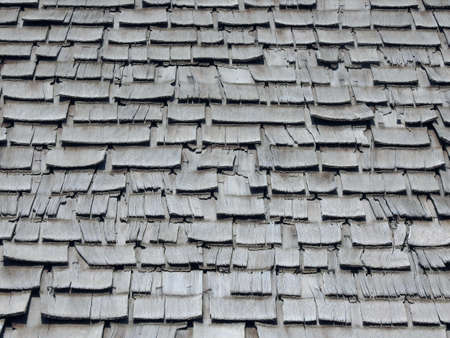 An abstract peeled old aged wooden roof shingle texture and backgroundの写真素材