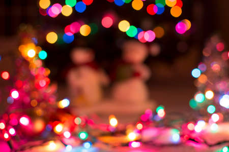 Colorful christmas light bokeh and blured snowman for backgroundの写真素材