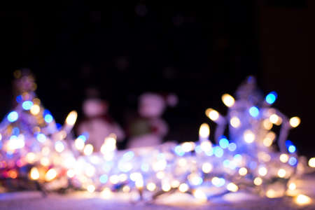 Colorful christmas light bokeh and blured snowman for backgroundの写真素材