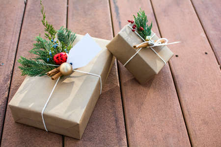 Brown paper holiday gift boxes outside on the deck and sunset shadow
