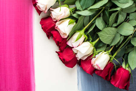 Mixed red and white roses lay flat on colorful stripes painted wood background, Top shot of red and white roses on colorful painted backgroundの写真素材