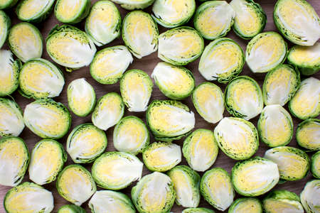 Fresh cut brussels sprout in half lay flat on wooden boardの写真素材