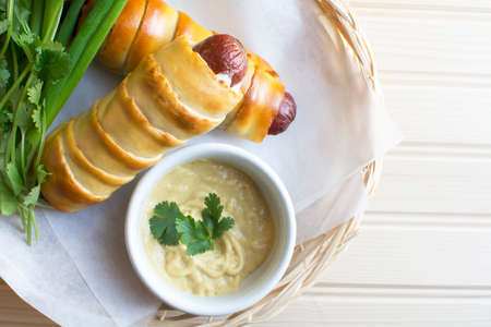 Close up pretzeldog in bamboo plate holder basket on wood backgroundの写真素材