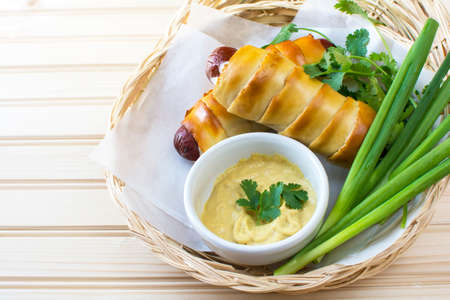 Close up pretzeldog in bamboo plate holder basket on wood backgroundの写真素材