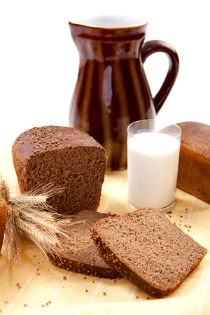 Fresh brown bread with a glass of milk and jugの写真素材