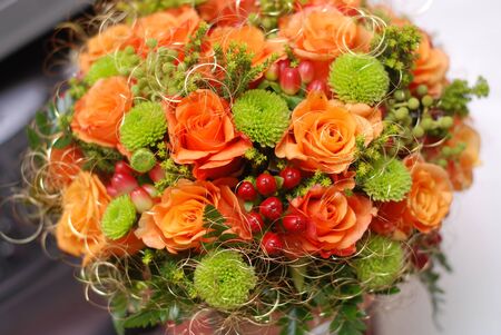 Wedding bouquet with orange roses and red berriesの写真素材