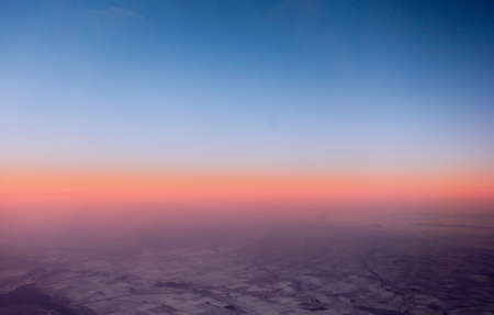Sunset over the ground and fields. View from aircraft airplaneの写真素材