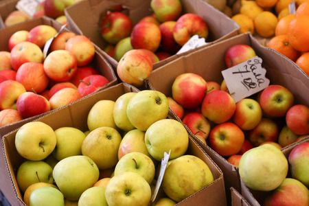 Bright colorful ripe apples laid out in the market stallsの写真素材
