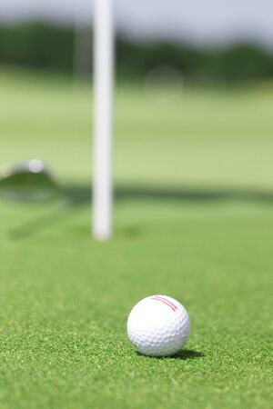 pictire of golf field with white golfball and holeの写真素材