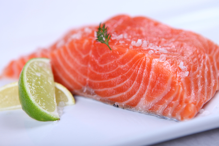 Raw fresh red salmon at white plateの写真素材