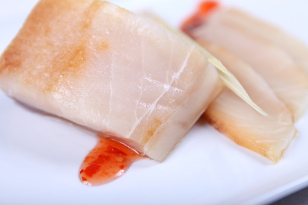 Fresh raw white fish decorated  with sauce and shopstick. Close-up