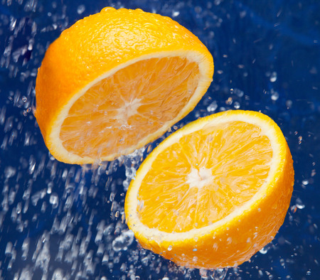 Fresh sweet orange under drops of waterの写真素材