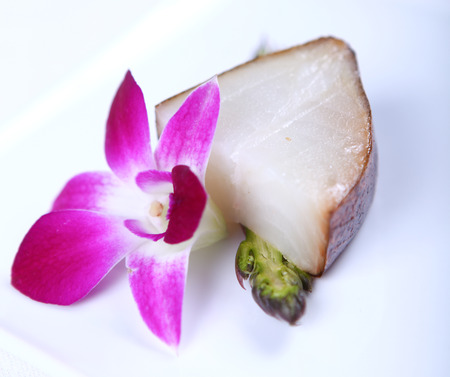Fresh white fish decorated with greens and flower. Close-upの写真素材