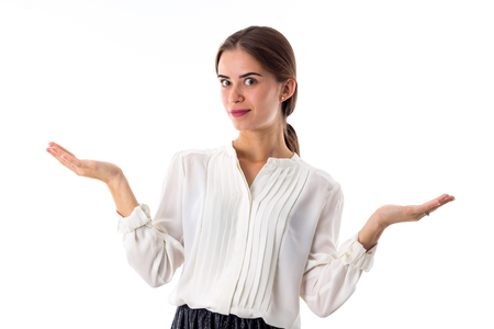 Young smiling woman in white blouse showing open hands on white background in studioの写真素材
