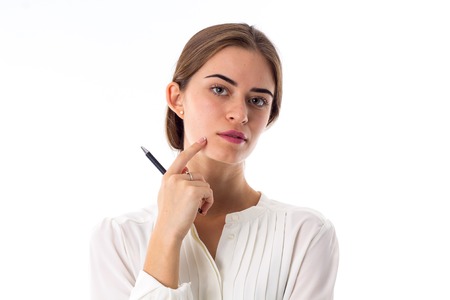 Young beautiful woman in white blouse holding a black pen in her hand on white background in studioの写真素材