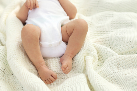 Little baby's legs on the white blanketの写真素材