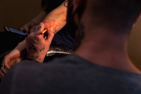 The tattoo artist is preparing the area that will be tattooed