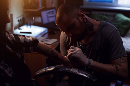 Tattoo artist is implanting coloring pigmant into elected area