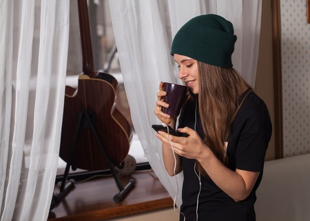 Woman hipster in green hat listening music and enjoying life