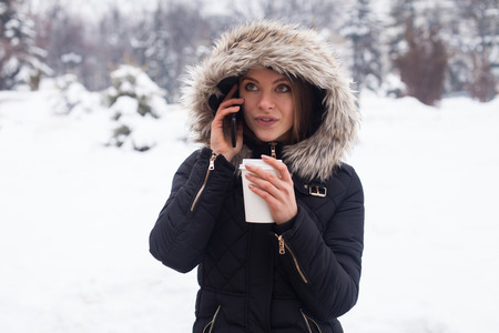 Woman drinking her hot beverage from cup. Winter season.