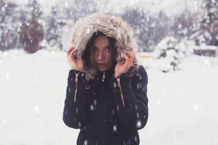 Cute young woman under showflakes in winter.の写真素材