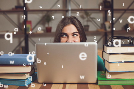 Crazy woman shows only her eyes looking out of her grey laptop 