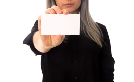 Young woman with gray hair in black shirt showing white card on white background in studioの写真素材