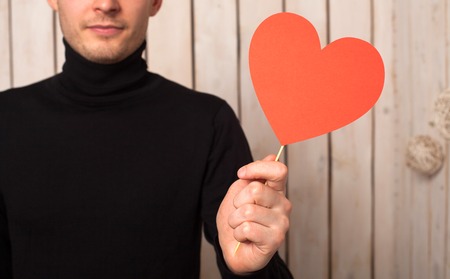 Man with red heart at wooden background. Valentine's day.の写真素材
