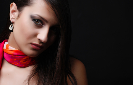 beautiful brunet woman in red scarf at black backgroundの写真素材