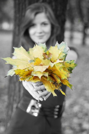 young happy beautiful woman with yellow maple leavesの写真素材