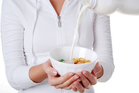 portrait of young woman with plate of muesli and milk