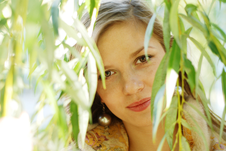 portrait of a beautiful woman with branch of weeping willowの写真素材