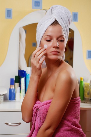 portrait of woman in towel near the mirrorの写真素材