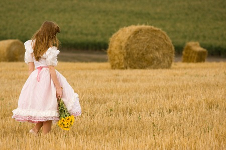 Woman in dress with flowers in the field