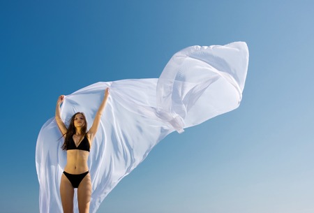 young beautiful woman standing with white material