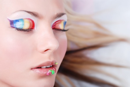 Face of beautiful girl with make-up as a rainbow on eyes and lipsの写真素材