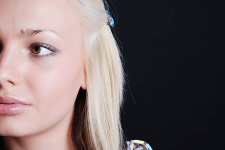 Beauty portrait of young blondie girl at black backgroundの写真素材