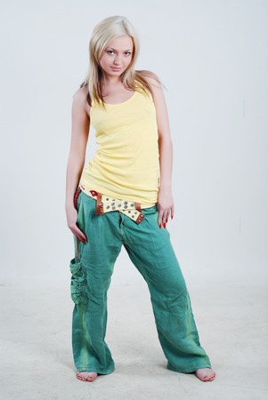 Pretty young girl dressed in yellow shirt and green knickerbockersの写真素材