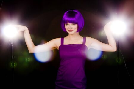 woman in purple wig and dress in bright illuminationの写真素材