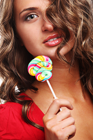 young beautiful woman with colored sweet candyの写真素材