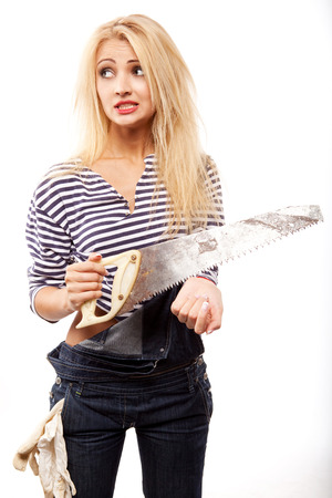 young blond woman in denim with big sawの写真素材