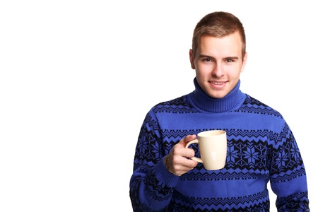 Young handsome man in blue sweater with white cup in his handsの写真素材