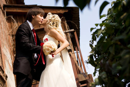 beautiful bride in a white dress with the groom kissingの写真素材