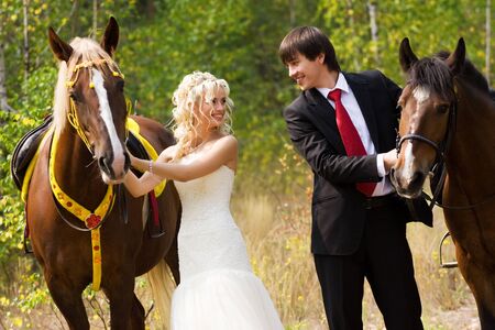 Bride and groom in forest with horsesの写真素材