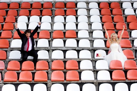 Bride and groom on the sport stadium seatsの写真素材